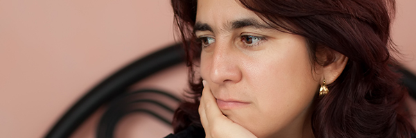 Woman sitting in her bed with a worried expression