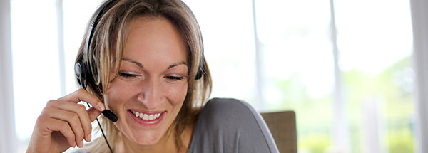 Portrait of woman with headset in front of laptop