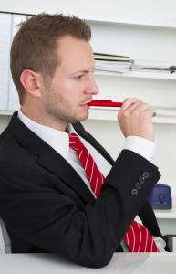 Profile of stressed business man chewing pen